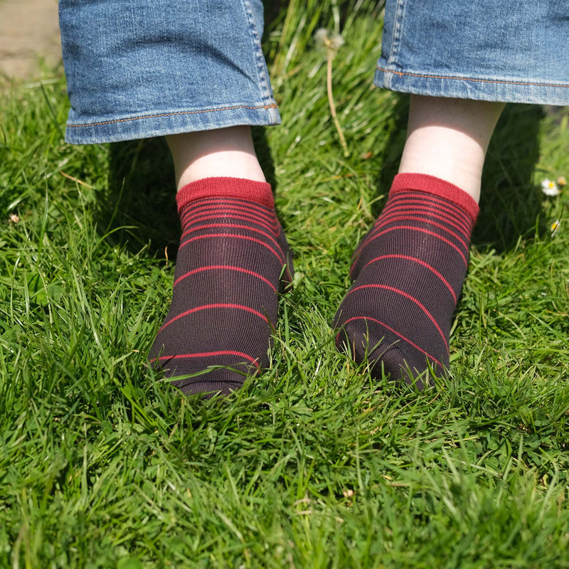 Man wearing Peper Harow burgundy Retro Stripe men's luxury trainer socks in grass