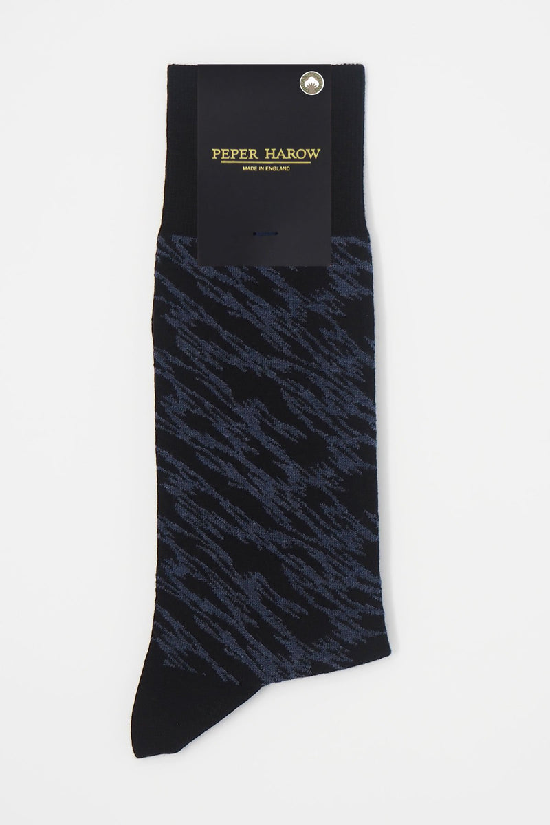 Pandemonium black men's luxury socks by Peper Harow, featuring a quirky navy pattern and navy toe and heel in packaging.