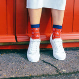 Woman wearing skirt, trainers and a pair of Coronation socks from Peper Harow