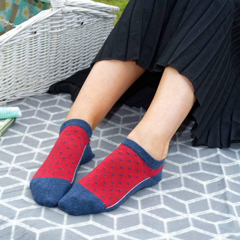 Woman sitting on a picnic blanket wearing women's denim Polka organic cotton trainer socks