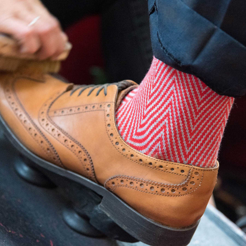 Man wearing red Peper Harow Lux Taylor men's luxury socks getting his shoe shined in London