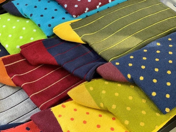 Many colourful Peper Harow socks with different patterns laid out