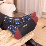 men wearing black cube socks sitting on the couch in the living room