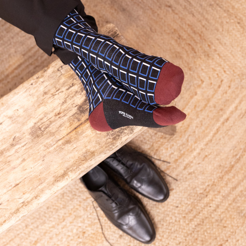 men wearing black cube socks sitting on the couch in the living room