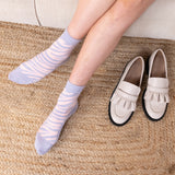 woman wearing purple zebra socks in white shoes