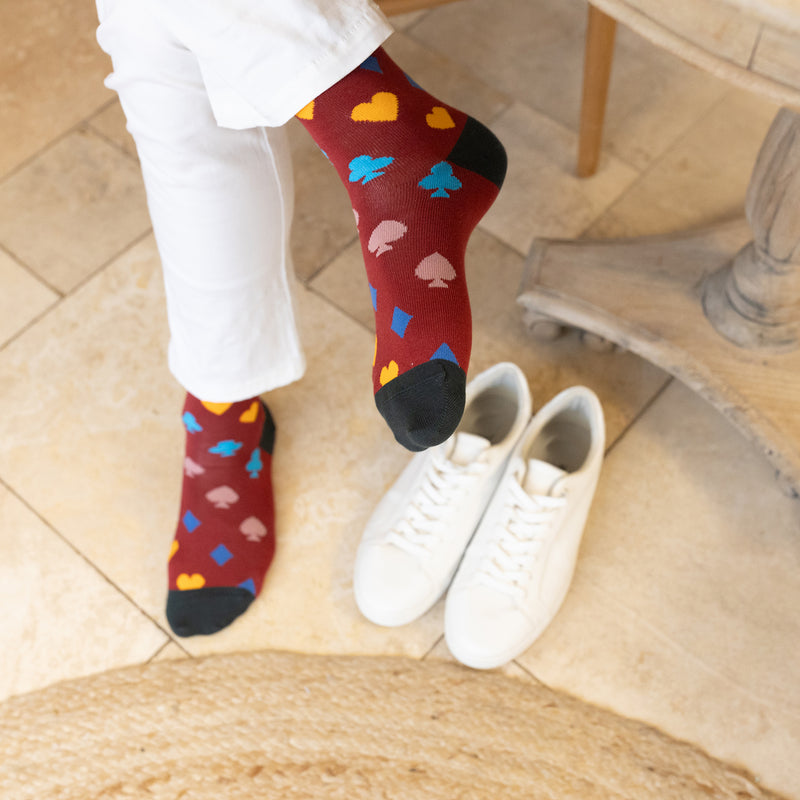 men wearing red Royal Flush Men's Socks in the kitchen holding magazine white trainers wearing white pants