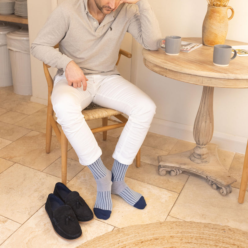 men wearing blue oxford stripe socks blue loafers and white pants
