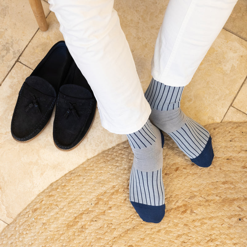 men wearing blue oxford stripe socks blue loafers and white pants