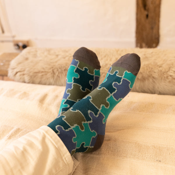 men wearing green jigsaw socks at home resting at the bed