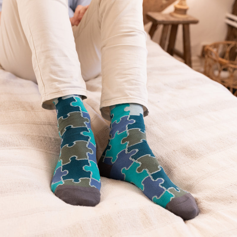 men wearing green jigsaw socks at home resting at the bed