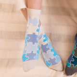woman wearing blue jigsaw socks sitting on the chair in the kitchen