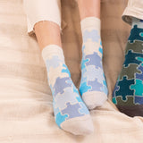 woman wearing blue jigsaw socks sitting on the chair in the kitchen