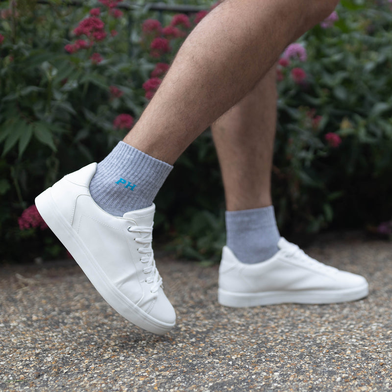 Man wearing Peper Harow grey Essentials men's luxury quarter crew sport socks with white trainers