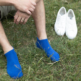 Man wearing Peper Harow blue Organic men's luxury trainer sport socks in grass