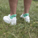 Man wearing Peper Harow green Organic men's luxury trainer sport socks with white trainers outdoors