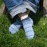 Man wearing Peper Harow blue Retro Stripe men's luxury trainer socks in grass
