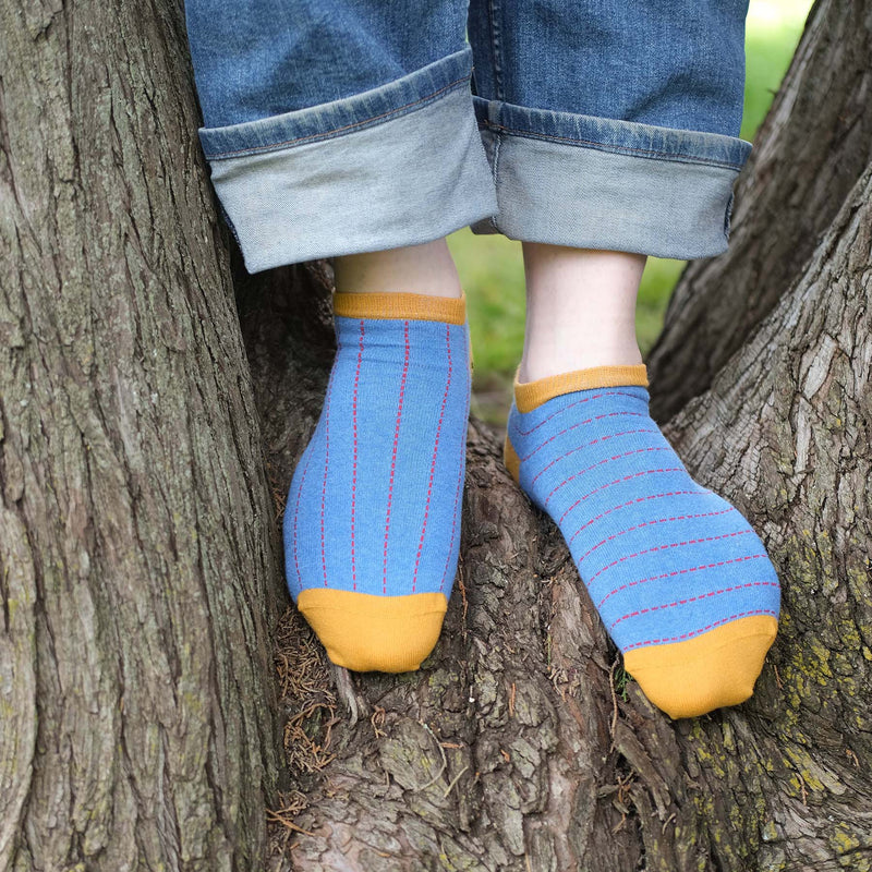 Man wearing Peper Harow blue Dash men's luxury trainer socks in a tree