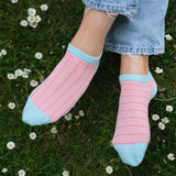 Women wearing Peper Harow pink Dash women's luxury trainer socks in grass