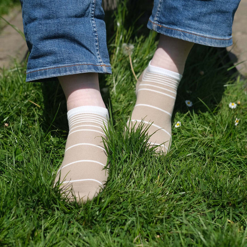 Man wearing Peper Harow cream Retro Stripe men's luxury trainer socks in grass