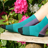 Woman sitting on a bench wearing and teal Anne ladies luxury socks from Peper Harow