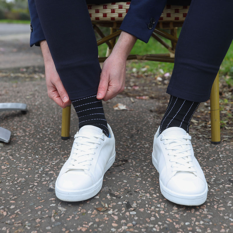 Man wearing Peper Harow black Dash men's luxury socks with white trainers