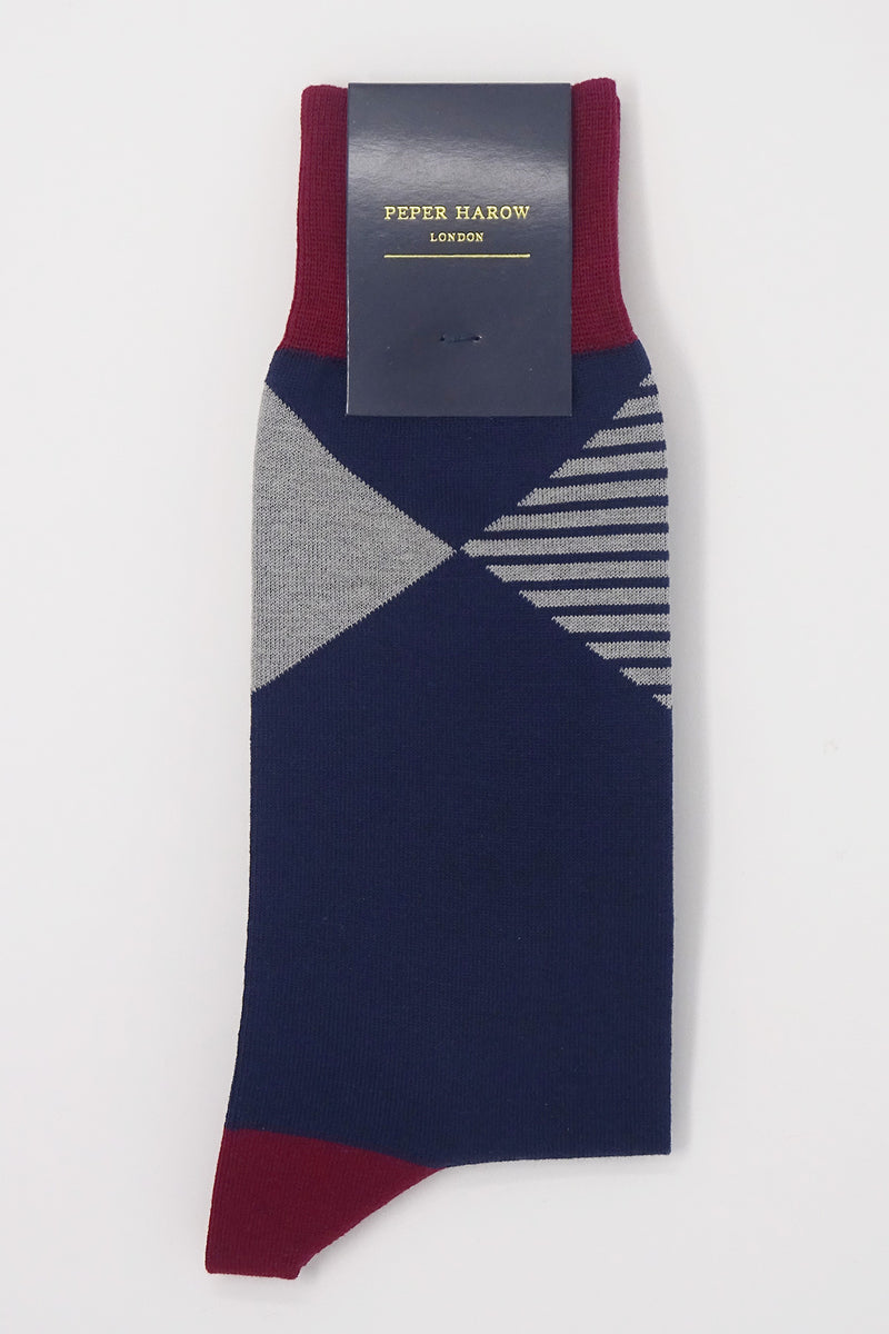 Navy socks with a red cuff, heel and toe, with a grey diamond shaped pattern around the ankle in packaging