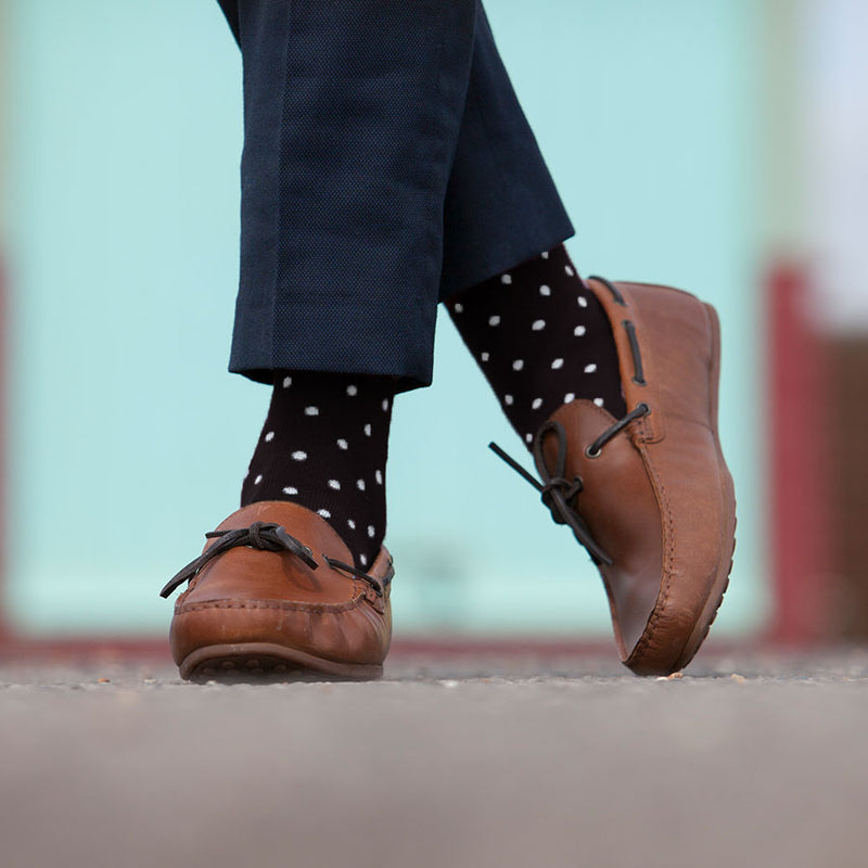 Man standing in smart trousers and smart leather shoes wearing black Pin Polka luxury men's socks by Peper Harow