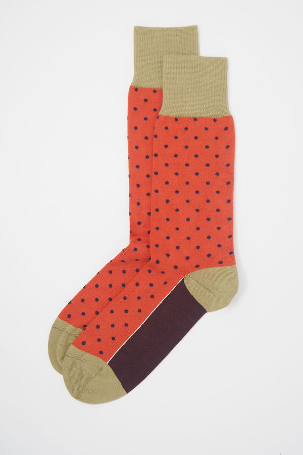 A pair of orange pin polka men's socks with purple polka dots and a beige heel, toe and cuff