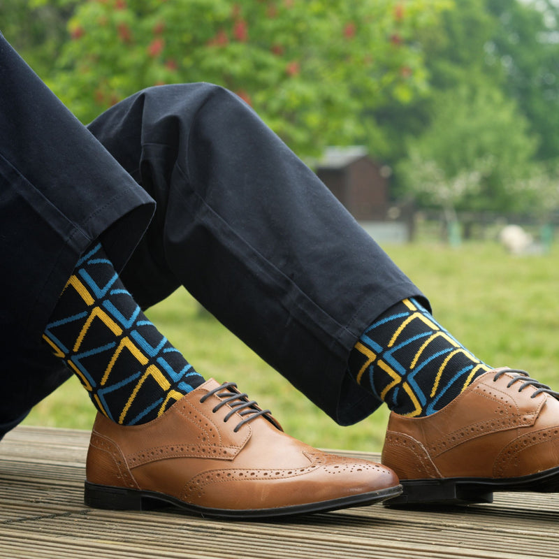 Man wearing navy trousers, brown shoes and black Septem luxury socks by Peper harow