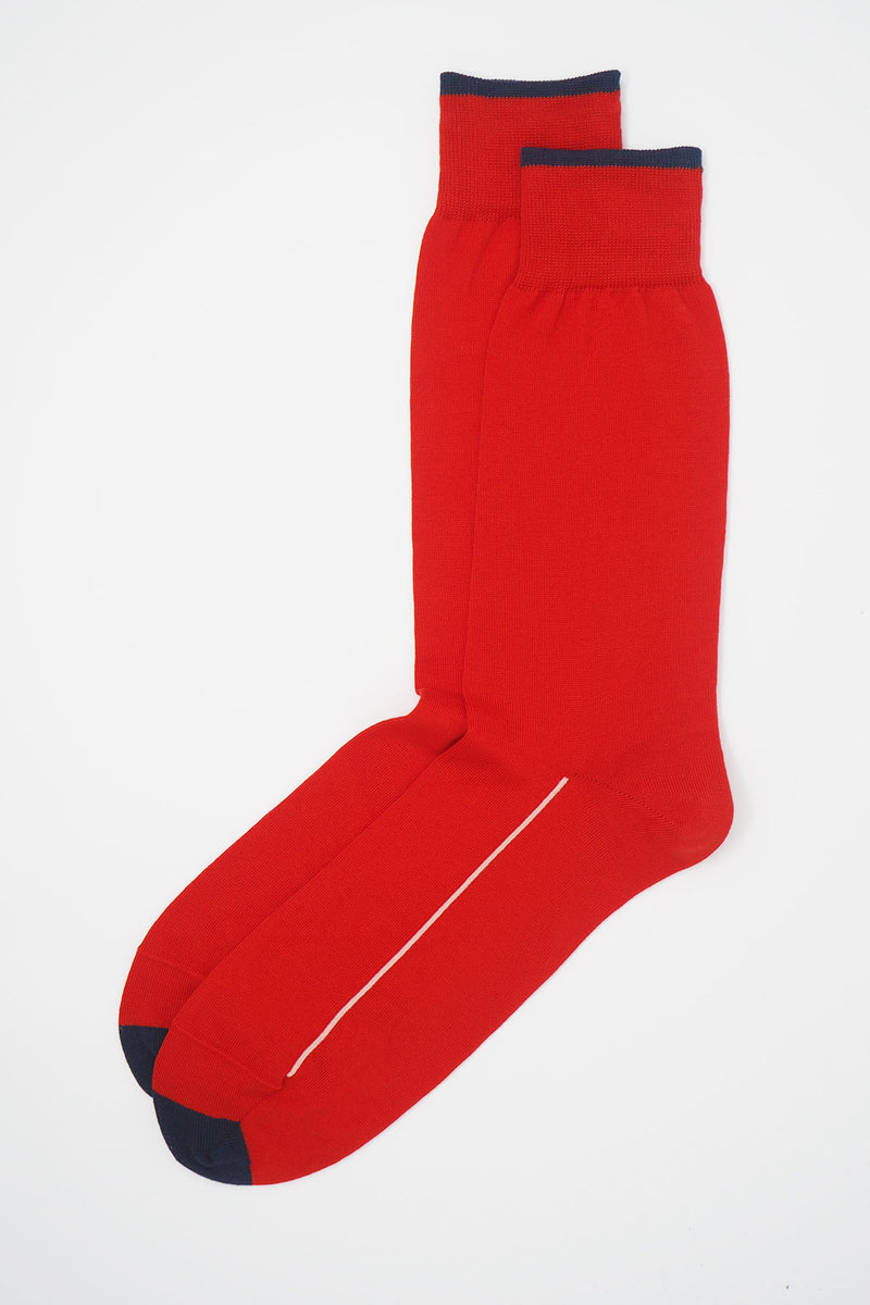 A pair of Cinnabar red square mile men's socks with a navy toe and cuff line, and a white line down the side of the foot