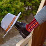 Stylish man wearing Peper Harow Red Symmetry Organic Cotton Socks with a hat on his shoe