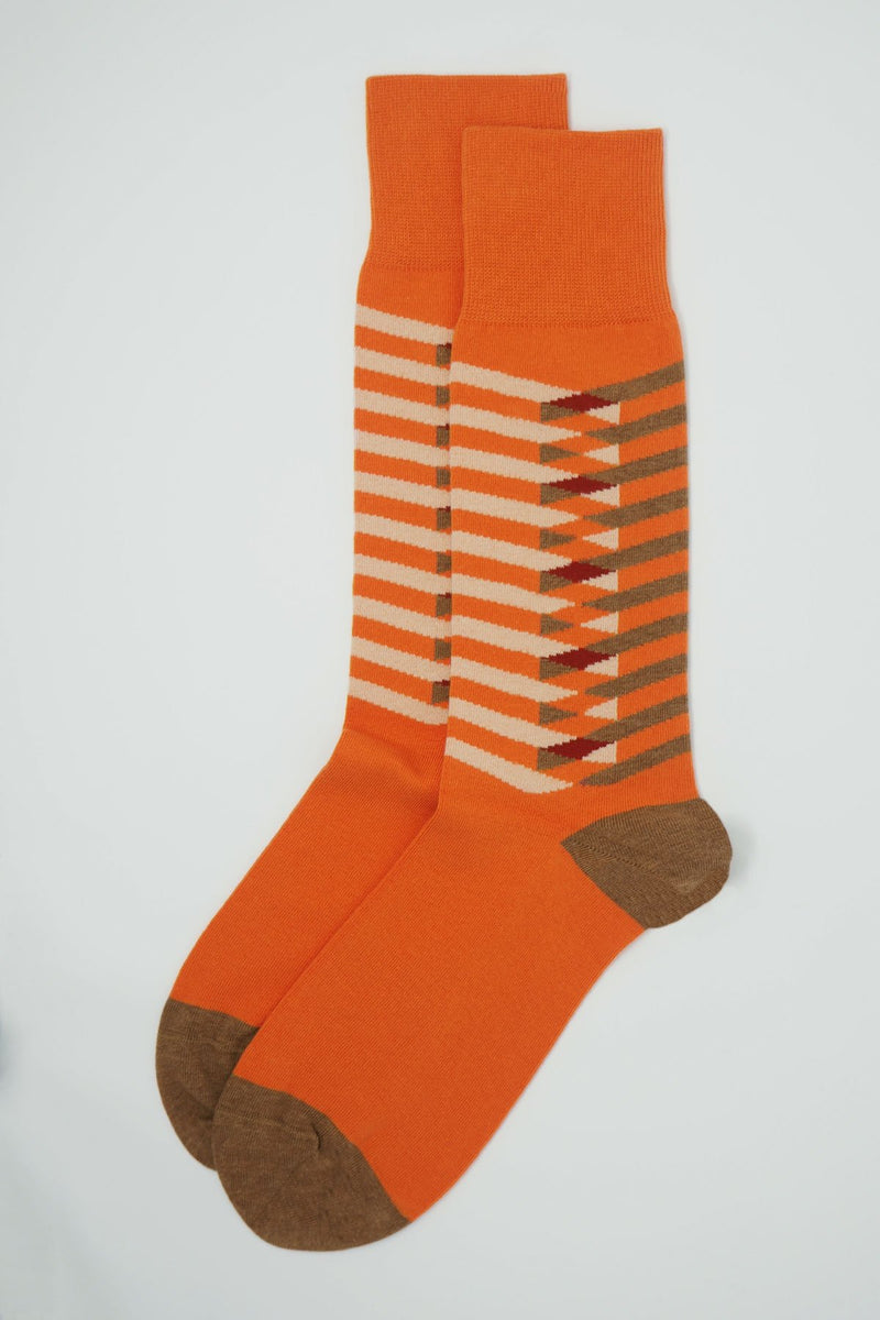 A pair of Symmetry orange men's luxury socks by Peper Harow, featuring stylish brown and white stripes, and a brown heel and toe.