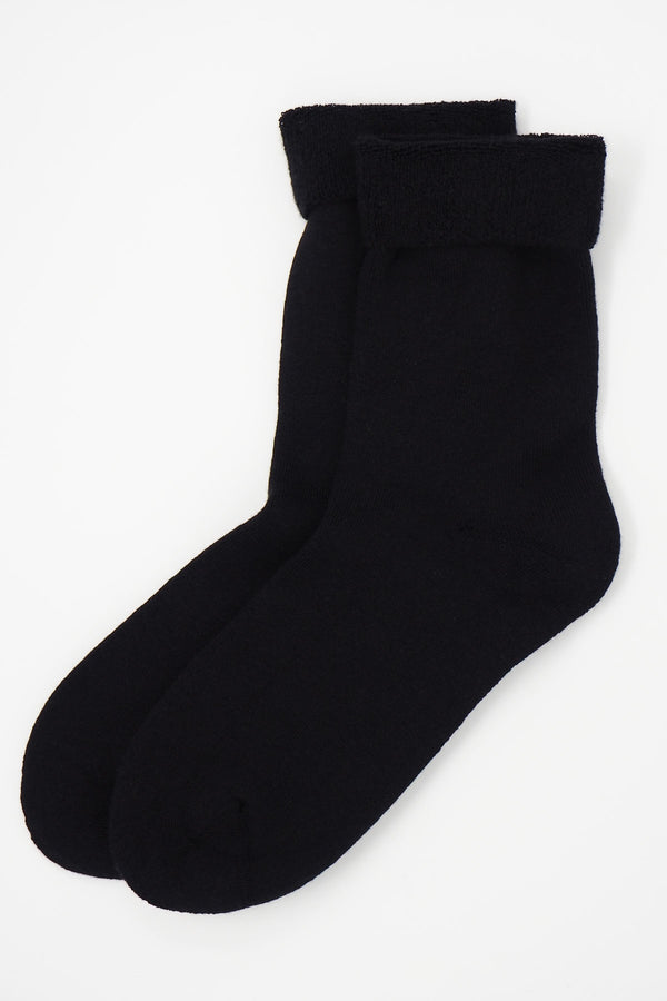 Two pairs of Peper Harow women's black Plain luxury bed socks showing fluffy inside