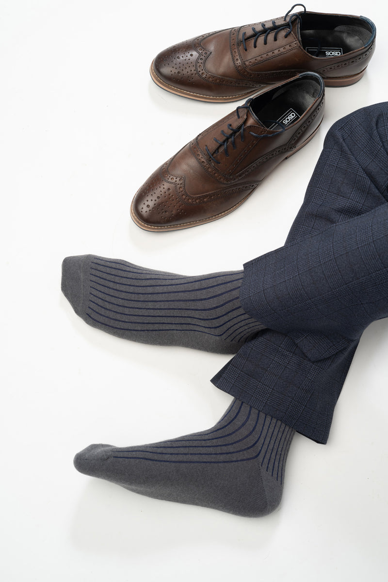 Man wearing Peper Harow charcoal Recycled Ribbed men's luxury socks with shoes beside him