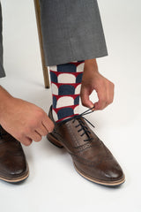 Man tying shoes wearing Peper Harow red Ouse men's luxury socks