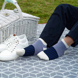 Man having a picnic wearing navy trousers and black Oxford Stripe luxury men's trainer socks by Peper Harow
