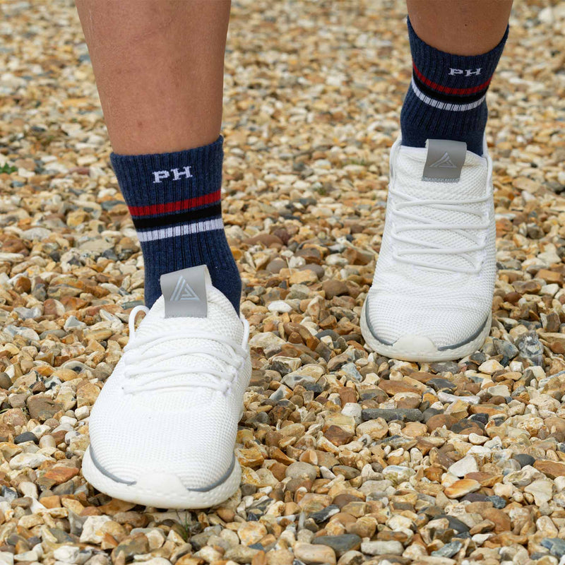 Man wearing white running shoes and Peper Harow navy Striped sport luxury organic socks