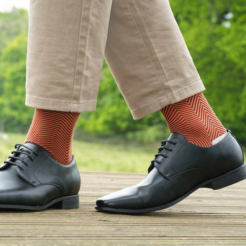 Man wearing tan trousers, black shoes and Peper Harow orange Lux Taylor men's luxury socks