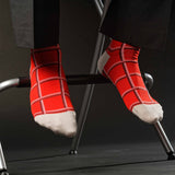 Man sitting on stool wearing black trousers and red Check men's luxury socks by Peper Harow