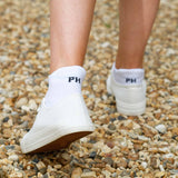 Woman in white trainers wearing Peper Harow plain white Organic women's luxury trainer sport socks