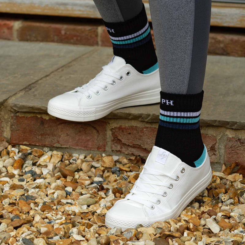 Woman wearing grey leggings, white trainers, and black Striped organic cotton sport socks by Peper Harow