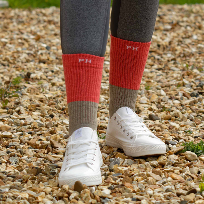 Woman wearing grey leggings, white trainers and coral Recycled Women's sport socks by Peper Harow
