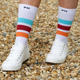 Woman wearing white trainers and white Peper Harow Striped luxury organic cotton sport socks
